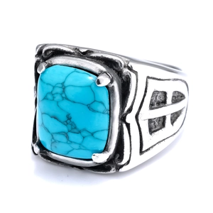 Detailed close-up of retro stainless steel ring with turquoise stone and floral patterns