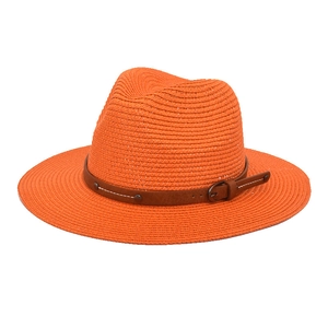 Detail of orange woven straw jazz hat with brown leather belt and metallic buckle