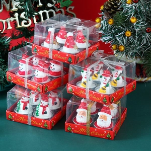 Detailed close-up of Christmas candle gift sets featuring Santa Claus and snowman shapes