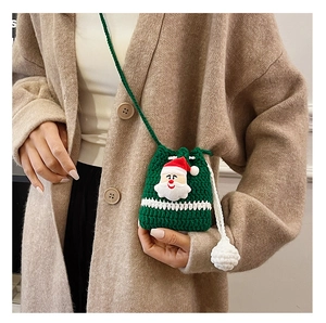 Detailed knit texture of green Santa Claus crochet mini bag worn on beige coat