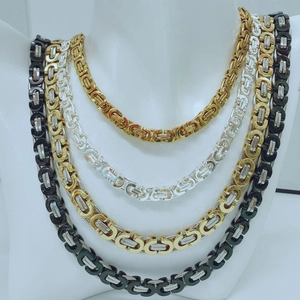 Detail showing layered Byzantine chains in gold, silver, and black on a white bust display