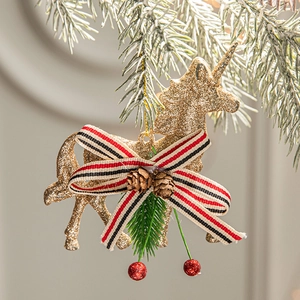 Golden glitter unicorn Christmas ornament with red bow and pine cones on tree