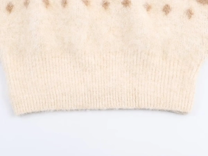Macro detail of ribbed cuff on plush jacquard knit top with brown polka dots