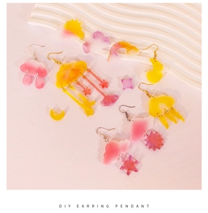Detail of pink and yellow gradient acrylic earring pendants in cloud and star shapes