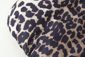Nahaufnahme von Leopardenmuster und Stepptextur an einer wattierten Winterjacke