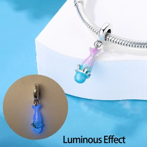 Macro detail of luminous fish charm on silver chain with dark glow effect preview