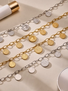 Detail of layered gold and silver coin necklaces with Elizabeth II portrait pendants