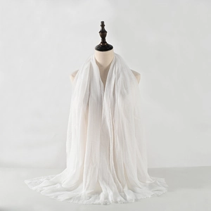 Elegant white crinkled cotton linen scarf for women draped on a mannequin