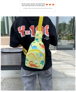 Close-up of yellow children's dinosaur print chest bag with adjustable webbing strap