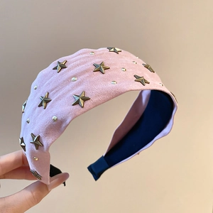 Détail du serre-tête en tissu rose avec des rivets étoiles en bronze et doublure anti-glisse