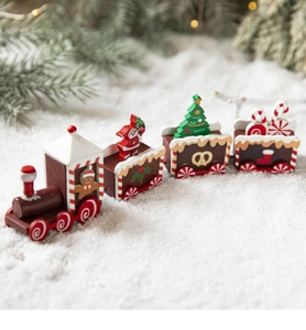Detail of wooden Christmas train decor with Santa, tree and gingerbread motifs in snow
