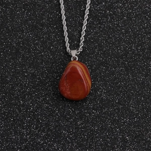 Detail of an irregular reddish-brown crystal pendant on a silver-tone metal link chain