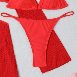 Detailed flat lay of red 3-piece bikini set with hollow knit drawstring beach sarong