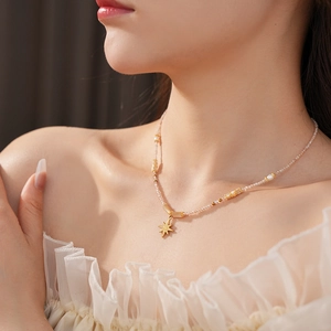Close-up of titanium star pendant necklace with freshwater pearls on a model's neck