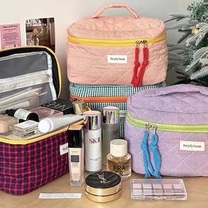 Quilted checkerboard cosmetic bags in multiple colors with top handle and zipper detail