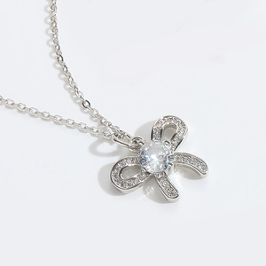 Detail of silver bow pendant necklace featuring sparkling cubic zirconia stones