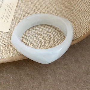 Detail of white resin geometric bangle with thick irregular square edge design