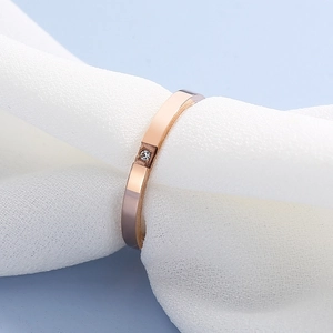 Bague minimaliste en acier inoxydable or rose sertie d'un zircon sur tissu tricoté blanc