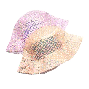 Detail of sequin bucket hats in pink and orange showing glossy textured surface