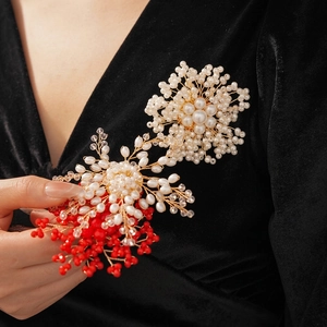 Elegant handmade floral brooch featuring white pearls and red beads with gold wire details