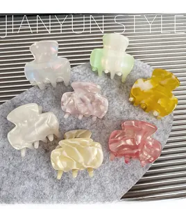 Flat lay of colorful acetic acid hair claw clips in various pearlescent marble finishes