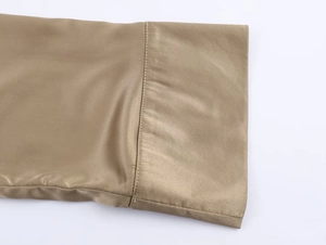 Détail du tissu en satin de soie et des coutures fines sur une chemise couleur champagne
