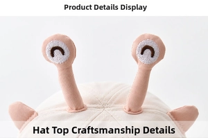 Detail of baby cotton bucket hat top with decorative 3D eyes and fine stitching