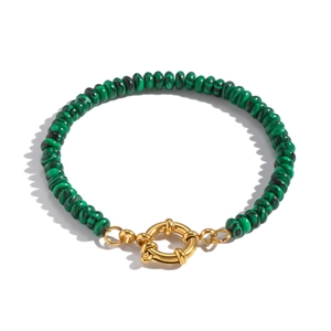 Close-up of green malachite beads with a large gold spring clasp on a beaded bracelet