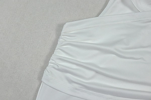 Detail of ruched white fabric showing the elastic texture and side drawstring stitching