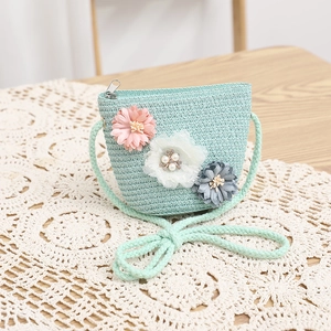 Dettaglio della borsa in paglia verde menta con fiori colorati e chiusura con zip in metallo