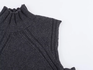 Detail of dark grey knit vest featuring a high mock neck and textured ribbing on the shoulder