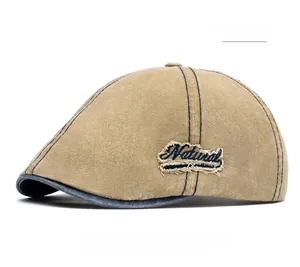 Detail of khaki vintage cotton newsboy cap with Natural embroidery and navy blue trim