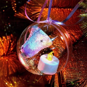Close-up of a clear Christmas ornament with a colorful cake model and warm LED candle inside