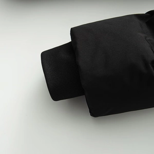 Close-up of black ribbed cuffs and windproof fabric on a slim fit winter jacket