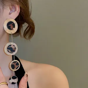 Leopard print geometric round tassel drop earrings with gold textured frames worn by model