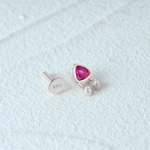 Macro detail of S925 sterling silver earring featuring pink triangle gemstone and hallmarked base