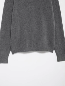 Detail view of dark grey knit sweater showing the fine wool texture and ribbed hem and cuffs