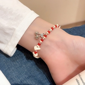 Detailed shot of handmade ceramic beaded bracelet with a silver cherry pendant on wrist