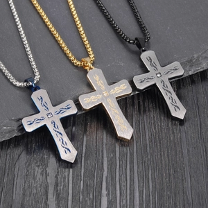 Detailed view of three-color titanium steel cross necklaces with inset diamonds on wood