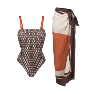 Polka dot swimsuit set with a geometric wrap skirt laid flat against a white background