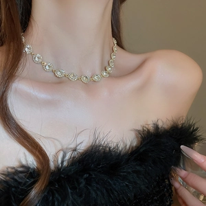 Gros plan du collier doré aux cristaux ronds porté avec élégance pour un style raffiné