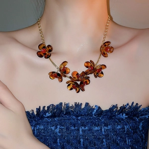 Close-up of vintage leopard print petal necklace with resin amber petals on model
