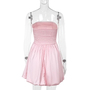 Detail view of pink satin strapless dress showing smocked elastic back and bubbly hem