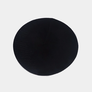 Vue de dessus d'un béret tricoté noir montrant une texture fine et un design sur fond gris