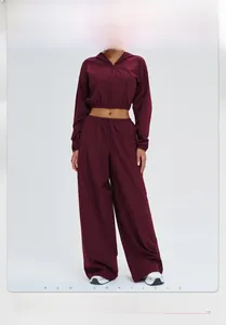 Detail of burgundy hooded zipper jacket and wide-leg sports trousers set in windproof fabric