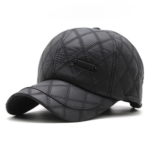 Detailed close-up of men's black quilted baseball cap with diamond pattern and metal logo