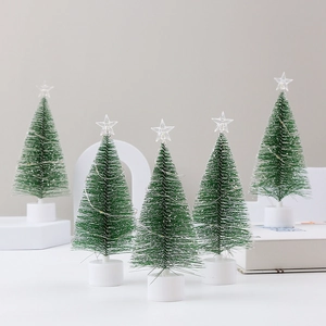Set of five mini green Christmas trees with LED lights and star toppers on white bases