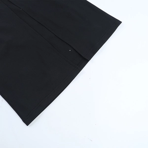 Détail en maille côtelée noire montrant la fente de l'ourlet d'une robe de soirée