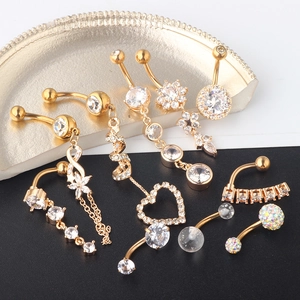 Detailed close-up of 10-piece gold navel rings set with zircons and tassel charms
