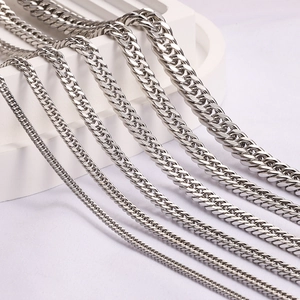 Polished silver stainless steel Cuban link chains in various thicknesses on white display
